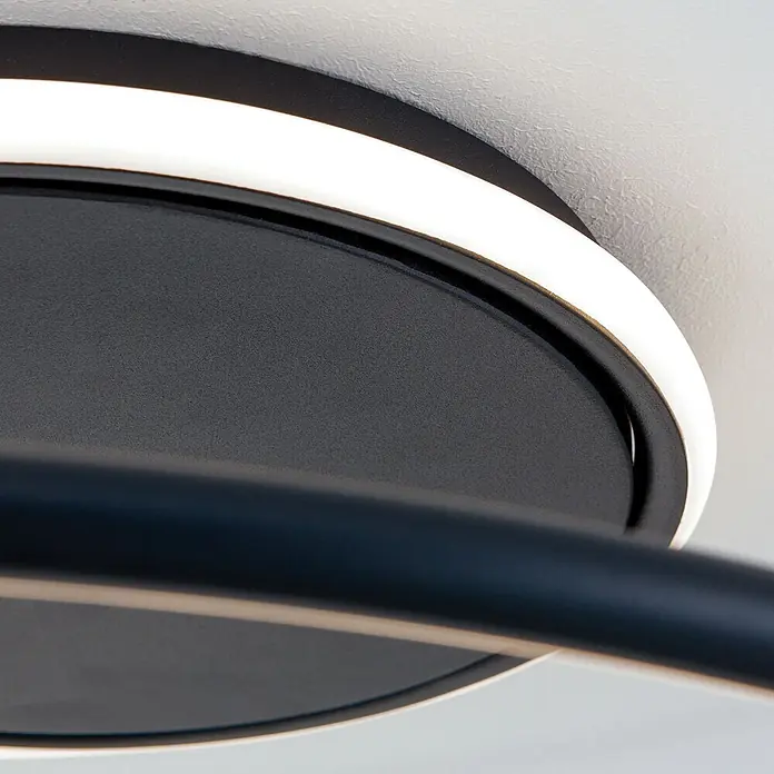 Orion Leuchten LED-Deckenleuchte rund -  - Nahaufnahme einer modernen schwarzen Deckenleuchte mit rundem Sockel und weißem LED-Lichtband, mit einem dunklen, gebogenen Arm.