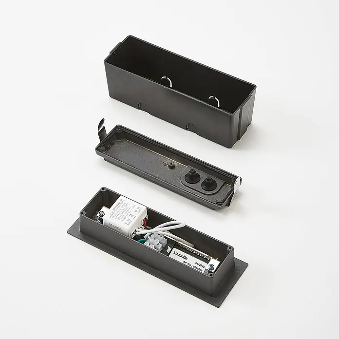 Lucande Außenwandleuchte Loya - schwarz, schwarz, IP54 - Zerlegtes schwarzes Elektrogehäuse mit internem Netzteil und Verkabelung.