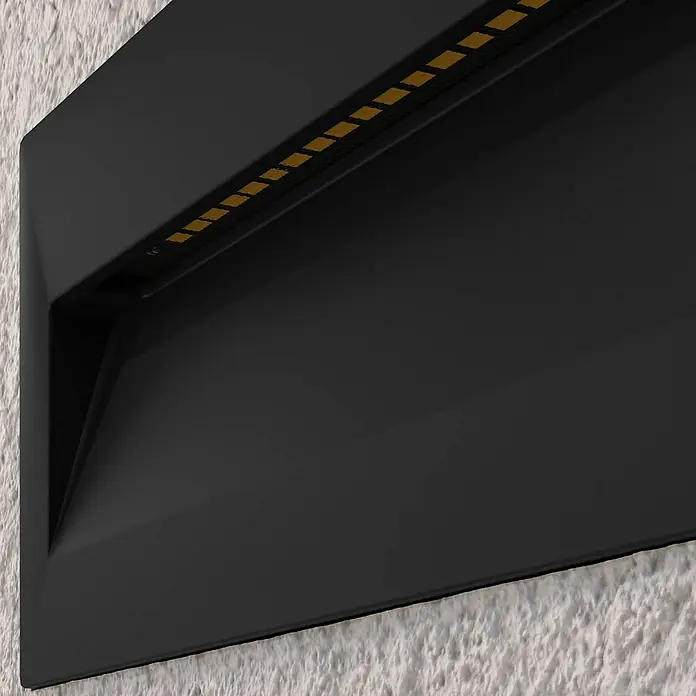 Lucande Außenwandleuchte Loya - schwarz, schwarz, IP54 - Schwarze, mattierte Wandleuchte mit linearer Anordnung von bernsteinfarbenen LEDs, an einer strukturierten Wand montiert.