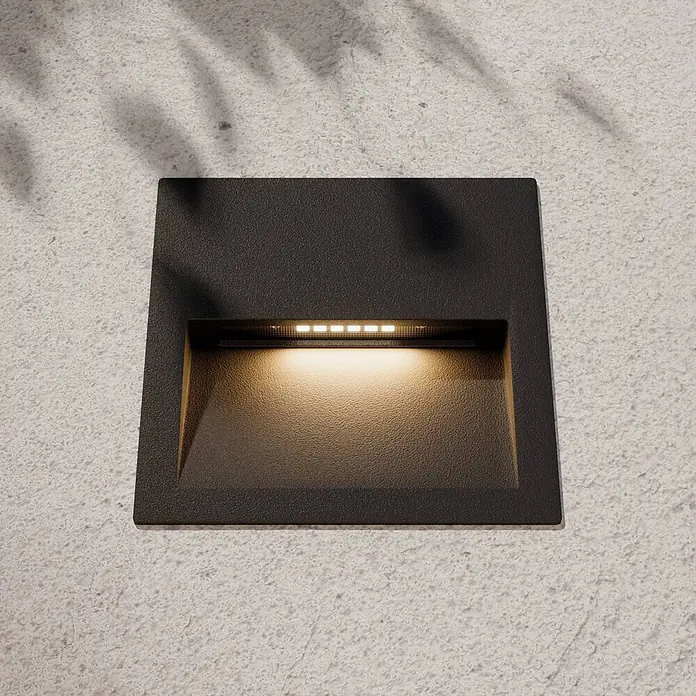 Lucande Außenwandleuchte Loya - schwarz, schwarz, IP54 - Dunkle, texturierte quadratische LED-Einbauwandleuchte, die warmes Licht abstrahlt.