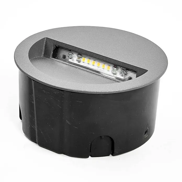 Lucande Außenwandleuchte Loya - 11,5 x 11,5 x 5,5 cm, schwarz, schwarz, IP54 - Runde graue Bodeneinbauleuchte mit einem linearen Streifen weißer und warmtöniger LEDs, in einem schwarzen zylindrischen Gehäuse.