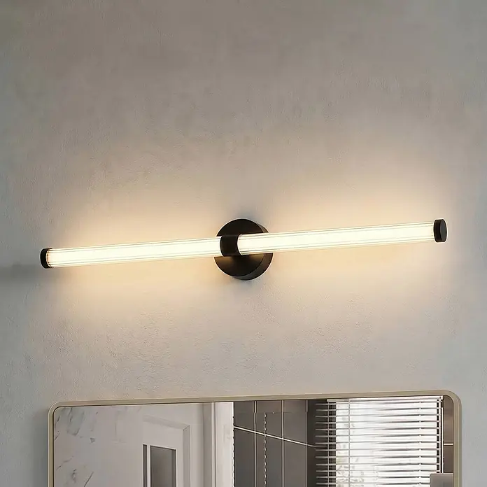 Lucande Wandleuchte Melisa - schwarz, weiß / opal - Beleuchtete moderne schwarze LED-Spiegelleuchte mit weißem Röhrendiffusor, horizontal über einem Spiegel montiert.
