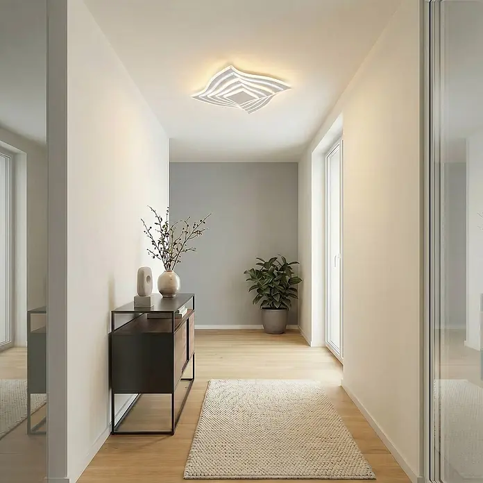 Lindby Deckenleuchte Rebeka - weiß / opal - Moderne weiße LED-Deckenleuchte mit geschichtetem Wellendesign, die einen Flur beleuchtet.