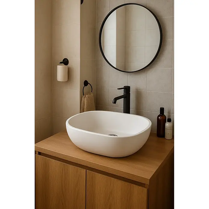 Camargue Lavabo de sobremesa Bali - 50 x 35 cm, Sin desbordamiento, Blanco - Lavabo ovalado blanco sobre mueble de madera clara con grifo negro, en baño moderno con espejo redondo negro.