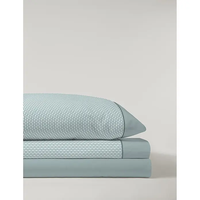 Juego de sábanas Serena Iker - L x An: 190 x 135 cm, 50 % Algodón - 50 % Poliéster, Verde, 3 pzs. - Almohada azul claro apilada con patrón geométrico blanco y dos sábanas lisas azul claro dobladas a juego.