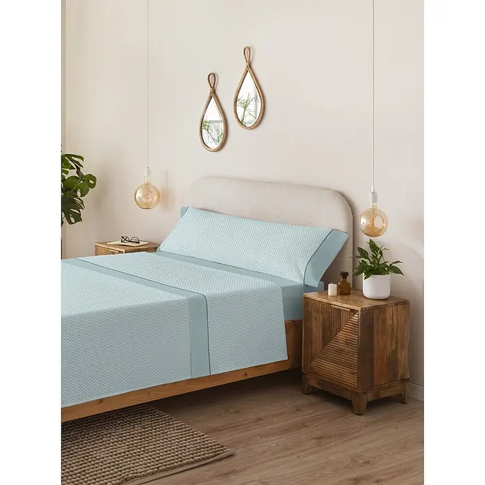 Juego de sábanas Serena Iker - L x An: 190 x 135 cm, 50 % Algodón - 50 % Poliéster, Verde, 3 pzs. - Juego de sábanas azul claro estampado con borde liso sobre una cama en un dormitorio.