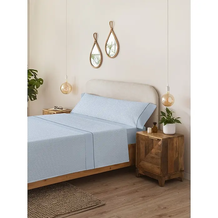 Juego de sábanas Serena Iker - L x An: 190 x 150 cm, 50 % Algodón - 50 % Poliéster, Azul, 4 pzs. - Juego de sábanas azul estampado con detalles azul claro, ordenado en una cama en un dormitorio luminoso.