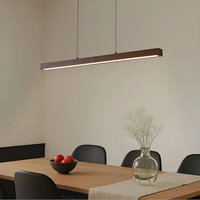 Lucande Pendelleuchte Emara - L x B x H: 115 x 10 x 5 cm, Holz dunkel, eiche dunkel, Schwarz, weiß - Lange, dunkelbraune, geriffelte lineare LED-Pendelleuchte über einem Holztisch.