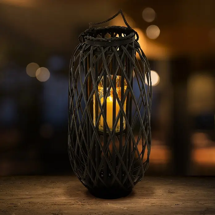ECD Germany Deko-Tischleuchte Laterne Ried Rattan Windlicht Retro-Laterne Korbgeflecht Gartenlaterne -  - Dunkle Weidenlaterne mit brennender Kerze auf Holztisch in gemütlicher Umgebung.
