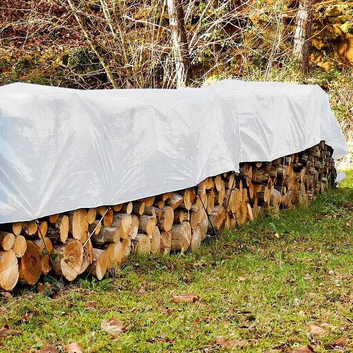 ECD Germany Abdeckplane Gartenplane 260g/m² mit Ösen Reißfeste Regenplane Polyethylen - L x B: 1.200 x 150 cm, 260 g/m², Kunststoff - Weiße Plane, die einen großen Stapel geschnittenen Brennholzes im Freien bedeckt.