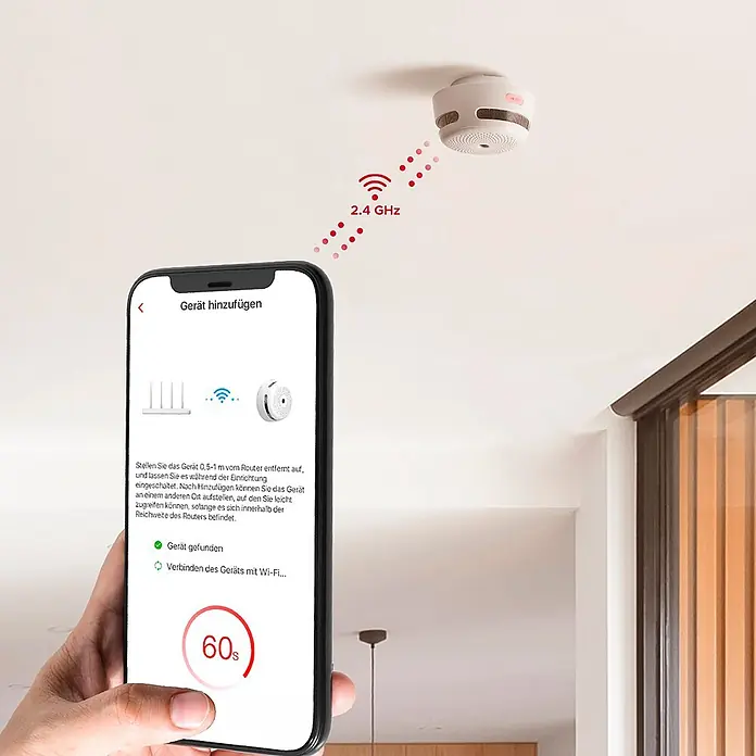 Simonrack Ecofire Detector de humo Smart - Diámetro: 78 cm, Señal de alarma: 85 dB - Detector de humo inteligente blanco en el techo, conectándose a través de Wi-Fi de 2,4 GHz, mostrado durante la configuración con una app de smartphone.