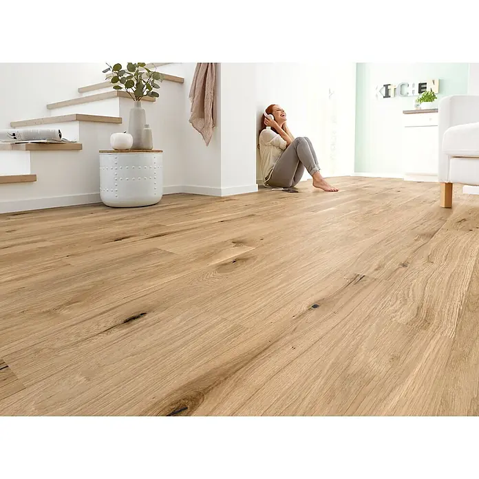 Decolife Designboden Naturestyle Pure - Oak Rustic, Landhausdiele, 1.220 x 185 x 9 mm - Heller Holzfußboden in einem modernen Wohnbereich, eine Person hört Musik.