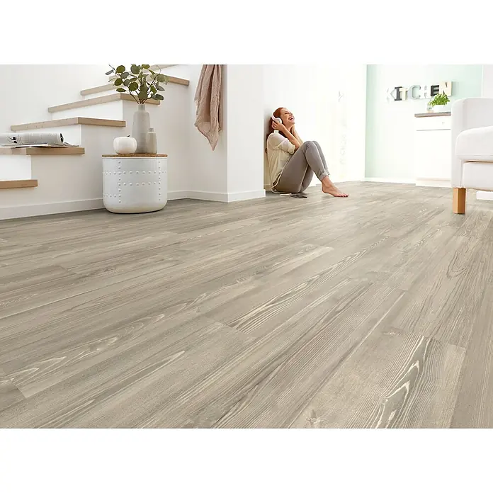 Decolife Designboden Naturestyle Pure - Oak Rock, Landhausdiele, 1.220 x 185 x 9 mm - Hellgraue Bodenplanken in Holzoptik in einem modernen Zuhause, die die natürliche Holzmaserung zeigen.