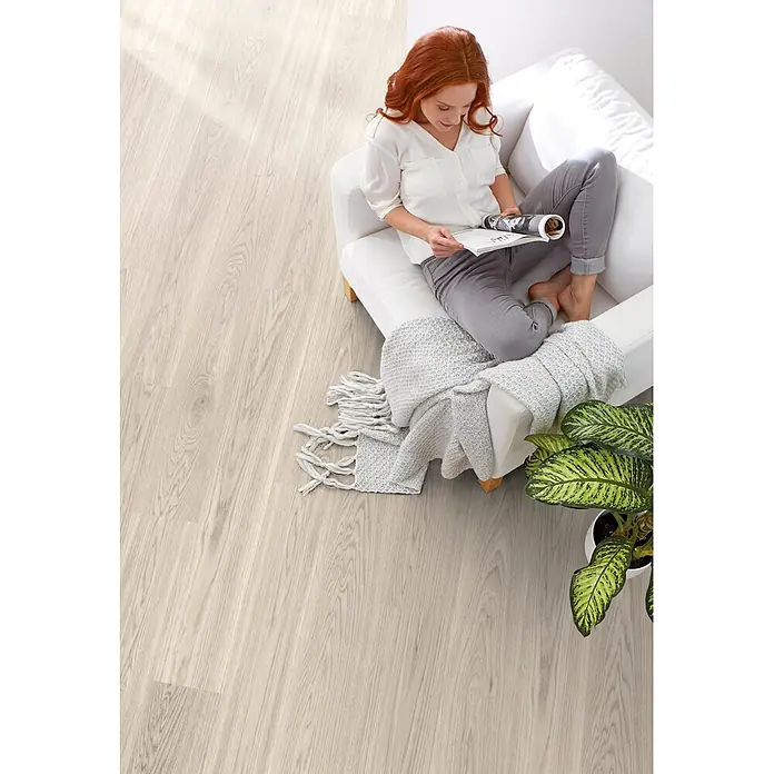 Decolife Designboden Naturestyle Pure - Oak Select White, Landhausdiele, 1.220 x 185 x 9 mm - Helles Holzdekor-Bodenbelag mit natürlicher Maserung in einer hellen Wohnzimmerumgebung.