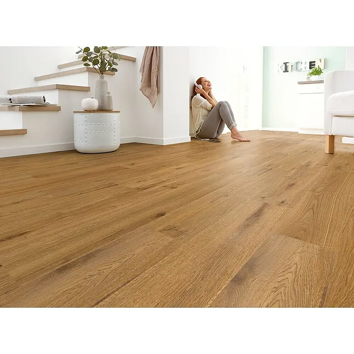 Decolife Designboden Naturestyle Pure - Oak Terra, Landhausdiele, 1.220 x 185 x 9 mm - Hellbrauner Holzlaminatboden in modernem Wohnbereich, seine natürliche Maserung und warme Atmosphäre zeigend.