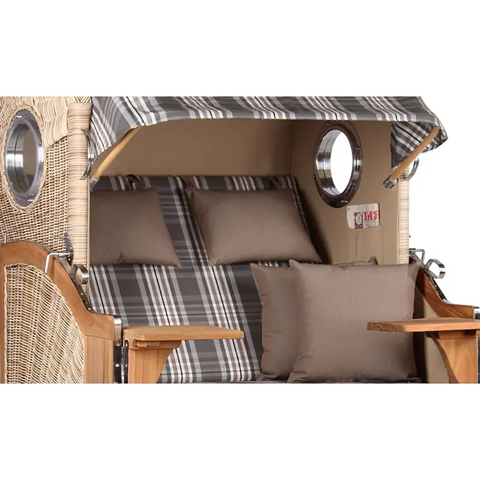 Mr. Deko Strandstuhl Strandkorb Düne - Teakholz. Polyrattan, Rückenlehne verstellbar, PE Shell, B x T x H: 125 x 80 x 170 cm - Nahaufnahme eines gemütlichen Strandkorbs aus Weide und Holz mit kariertem Bezug, braunen Kissen, Bullaugen und Holznebenplatten.