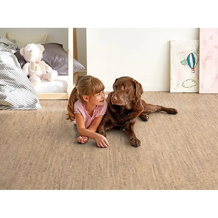 Corklife Studiostyle Korkboden - Almada Beige, 905 x 295 x 10,5 mm - Heller Korkboden mit natürlichen Maserungen in einem Kinderzimmer, auf dem ein Mädchen und ein Hund bequem liegen.