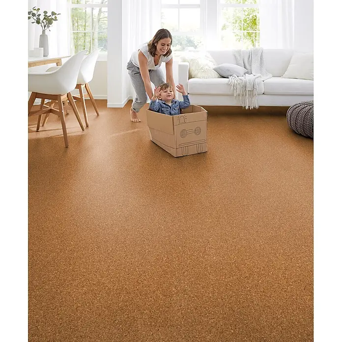 Corklife Studiostyle Korkboden - Beja, 905 x 295 x 10,5 mm - Natürlicher Korkboden in hellem Wohnzimmer. Eine Mutter spielt mit Kind in Kartonkiste, zeigt warmen Ton und familienfreundliche Nutzung.