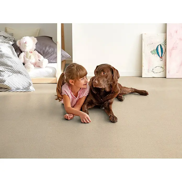 Corklife Korkboden Earth Tons - Grit Weiß, 905 x 295 x 10,5 mm - Hellbeiger strukturierter Bodenbelag mit einem Mädchen und einem Labrador, der Strapazierfähigkeit für Spiele zeigt.