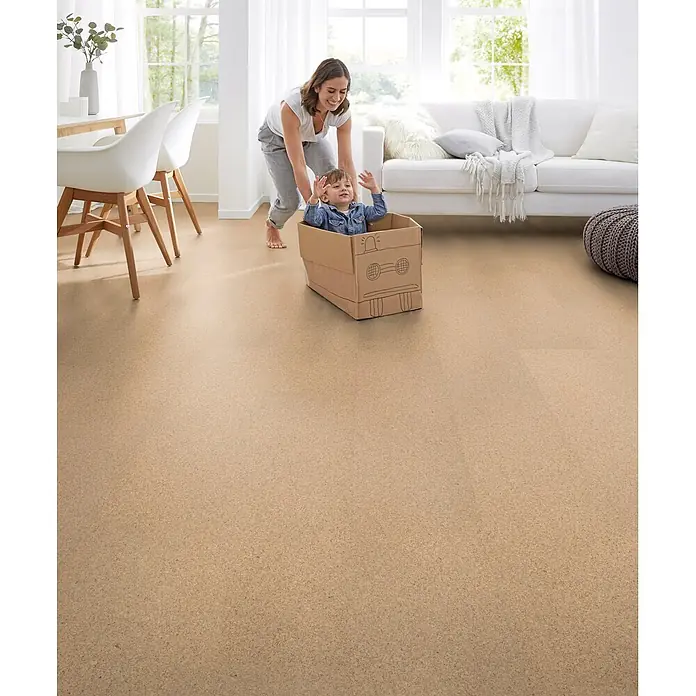 Corklife Korkboden - Sand Creme, 905 x 295 x 10,5 mm - Natürlicher beiger Korkboden in einem hellen Wohnzimmer, wo eine Mutter ihr Kind in einem Kartonauto schiebt.