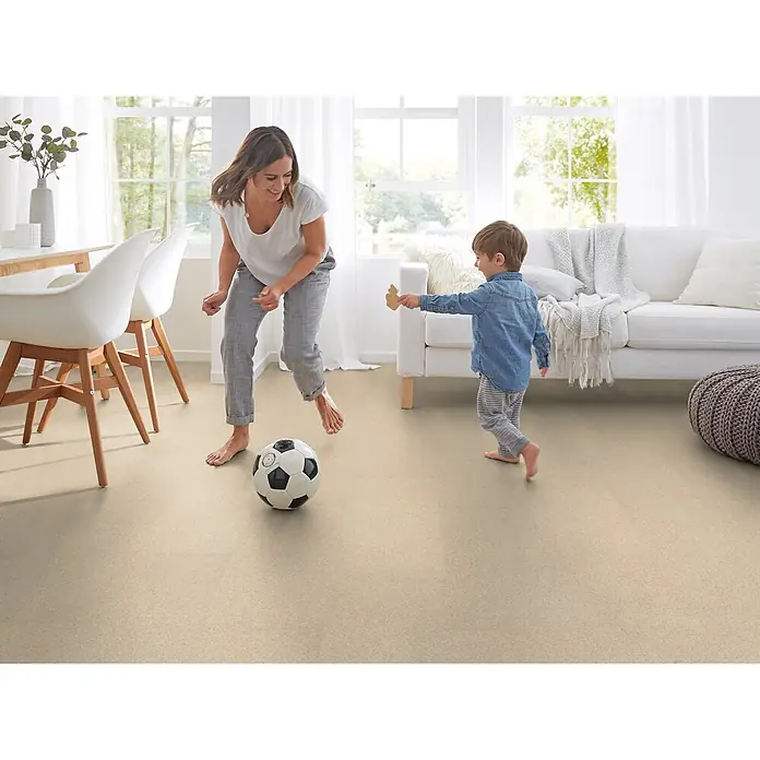Corklife Korkboden Earth Tons - Grit Weiß, 905 x 295 x 10,5 mm - Heller, beiger Bodenbelag in einem Wohnzimmer, wo eine Frau und ein Kind Fußball spielen, was seine Strapazierfähigkeit zeigt.