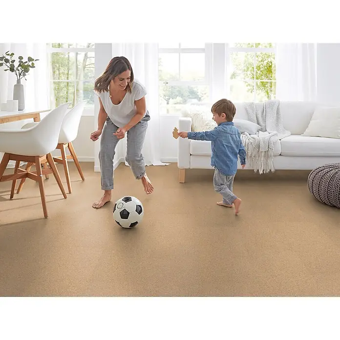 Corklife Korkboden - Sand Creme, 905 x 295 x 10,5 mm - Heller, texturierter Teppichboden in einem hellen Wohnzimmer, wo Mutter und Kind mit einem Fußball spielen.