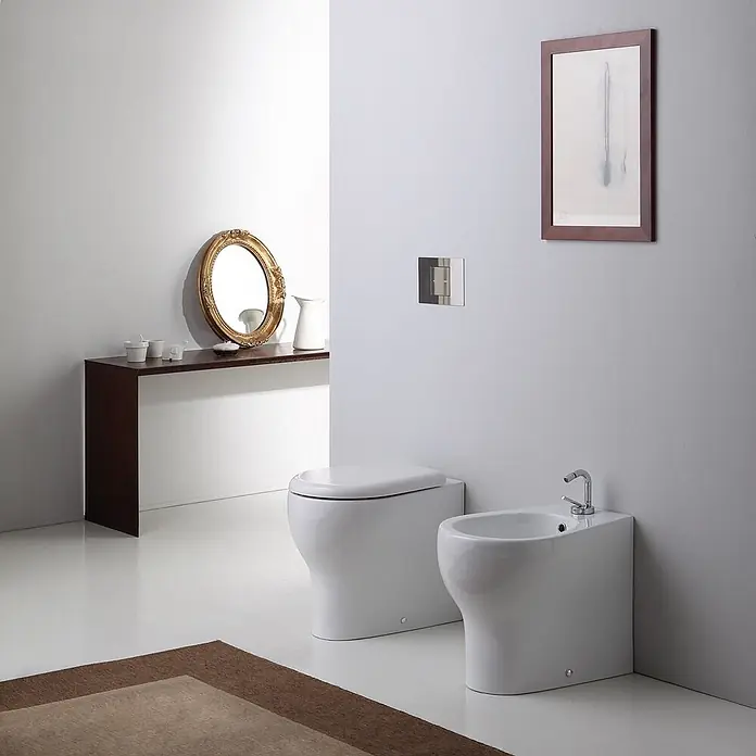 Kiamami Valentina Stand-WC-Kombination - Mit Spülrand, WC Abgang: Senkrecht, Weiß - Weißes, bodenstehendes WC und Bidet in einem modernen Badezimmer.