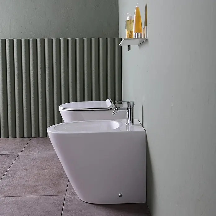 Kiamami Valentina Stand-WC-Kombination - Spülrandlos, WC Abgang: Senkrecht, Weiß - Weißes Keramik-WC und Bidet mit Chromarmatur.