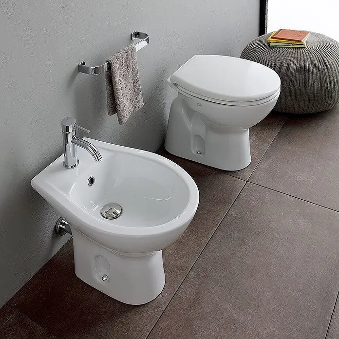 Kiamami Valentina Stand-WC-Kombination - Mit Spülrand, WC Abgang: Senkrecht, Weiß - Weißes Keramik-Bidet mit Chromarmatur und passender Toilette im modernen Bad.