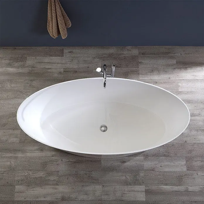 Kiamami Valentina Freistehende Badewanne - L x B: 1.580 x 718 cm, ABS-Kunststoff und Acryl, Weiß - Weiß-ovale freistehende Badewanne mit Chromarmatur auf Holzboden.