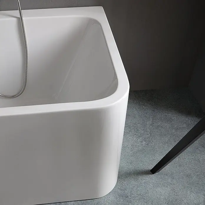 Kiamami Valentina Freistehende Badewanne - L x B: 1.700 x 750 cm, ABS-Kunststoff und Acryl, Weiß - Eine weiße, moderne Badewanne mit Duschschlauch, in einem zeitgenössischen Bad.