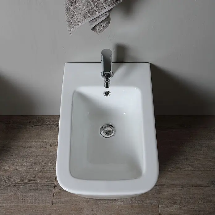 Kiamami Valentina Stand-WC-Kombination - Spülrandlos, WC Abgang: Senkrecht, Weiß - Weißes Keramik-Bidet mit Chromarmatur und Ablauf.