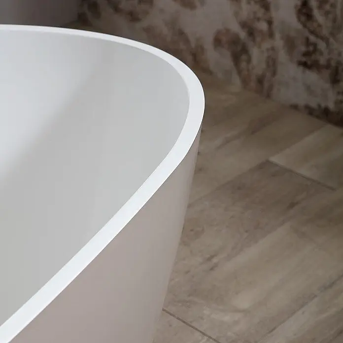 Kiamami Valentina Freistehende Badewanne - L x B: 1.570 x 710 cm, ABS-Kunststoff und Acryl, Beige - Detail eines weißen, glatten Badewannenrandes in einem modernen Badezimmer.