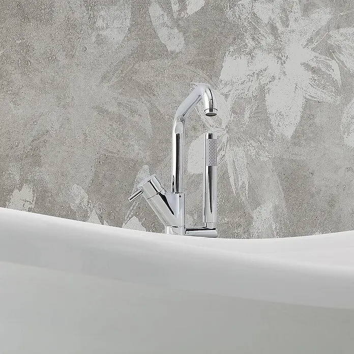 Kiamami Valentina Freistehende Badewanne - L x B: 1.670 x 752 cm, ABS-Kunststoff und Acryl, Weiß - Verchromte Wannenarmatur mit hohem Auslauf und Handbrause, montiert auf dem Rand einer weißen Badewanne.
