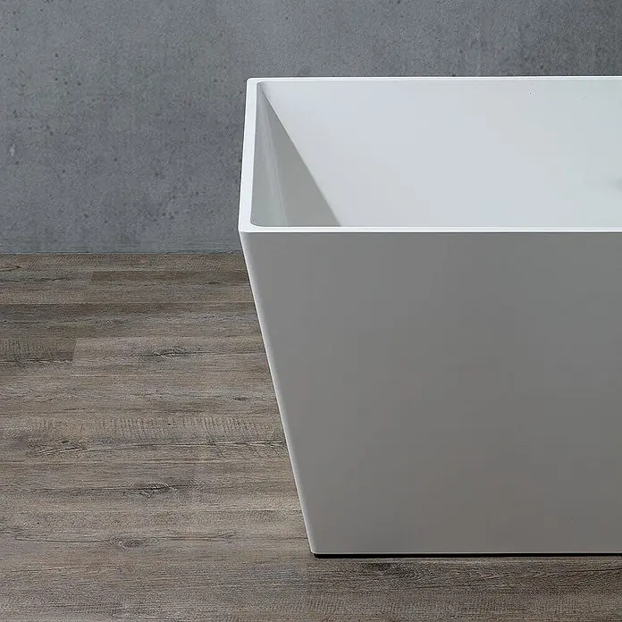 Kiamami Valentina Freistehende Badewanne - L x B: 1.590 x 650 cm, ABS-Kunststoff und Acryl, Weiß - Weiße, freistehende, rechteckige Badewanne mit modernem, sich verjüngendem Design auf Holzboden.