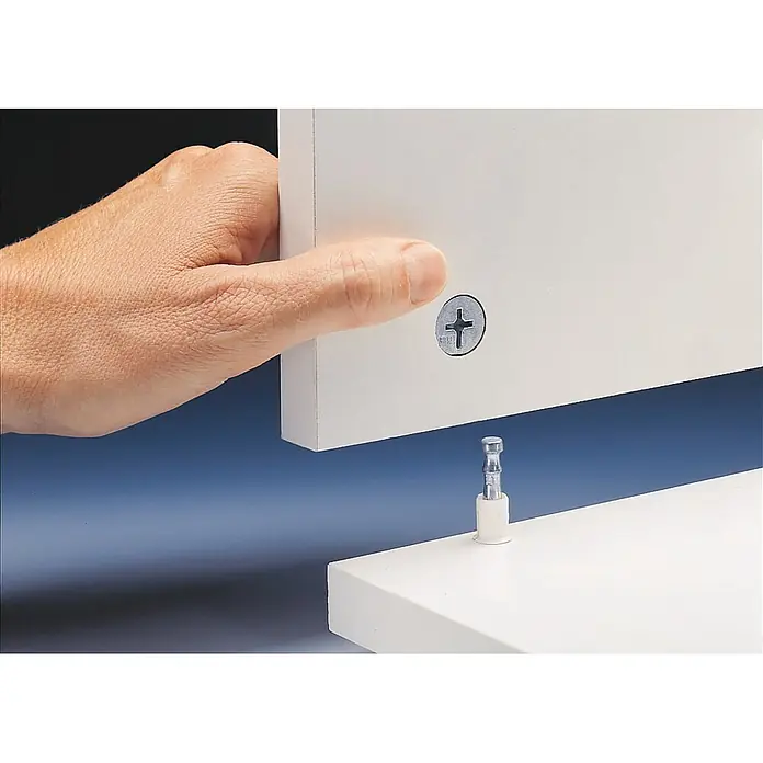 Optifit Küchenleerblock Bengt932 - Breite: 210 cm, Weiß, Ohne Elektrogeräte - Eine Hand positioniert eine weiße Platte mit Exzenterverbinder-Schraube über einem Exzenterverbinder-Dübel für Möbelmontage.