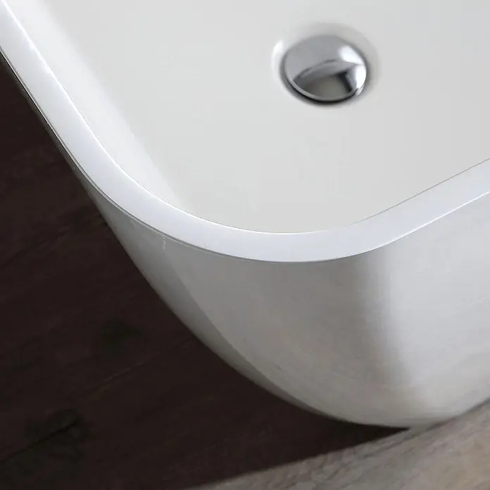Kiamami Valentina Freistehende Badewanne - L x B: 1.590 x 705 cm, ABS-Kunststoff und Acryl, Weiß - Moderne weiße Badewanne mit Chromablauf, auf dunklem Holzboden.