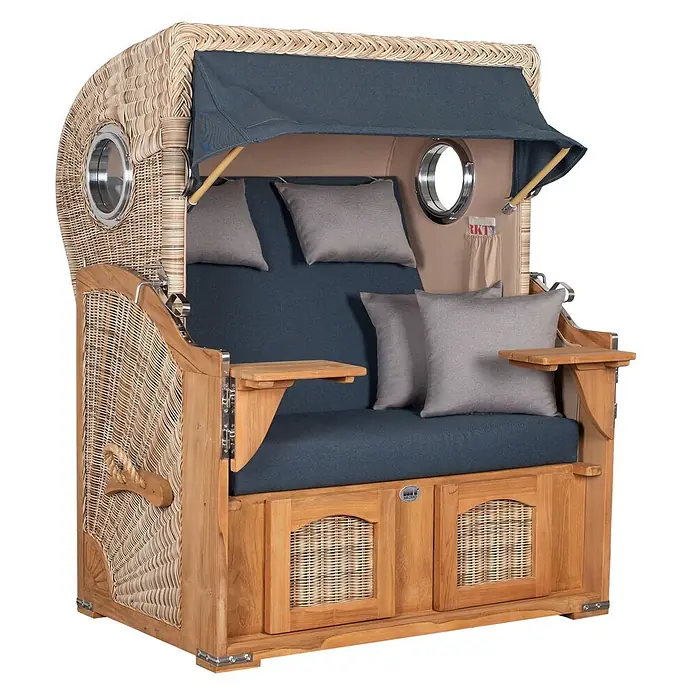 Mr. Deko Strandstuhl Strandkorb Düne Bullauge Teak PE Shell Dessin 593 - Teakholz. Polyrattan, Rückenlehne verstellbar, PE Shell, B x T x H: 125 x 80 x 170 cm - Ein traditioneller Strandkorb aus geflochtenem Korbgeflecht und hellem Holz, mit blauen Stoffpolstern, grauen Kissen, einem Verdeck und Bullaugenfenstern.