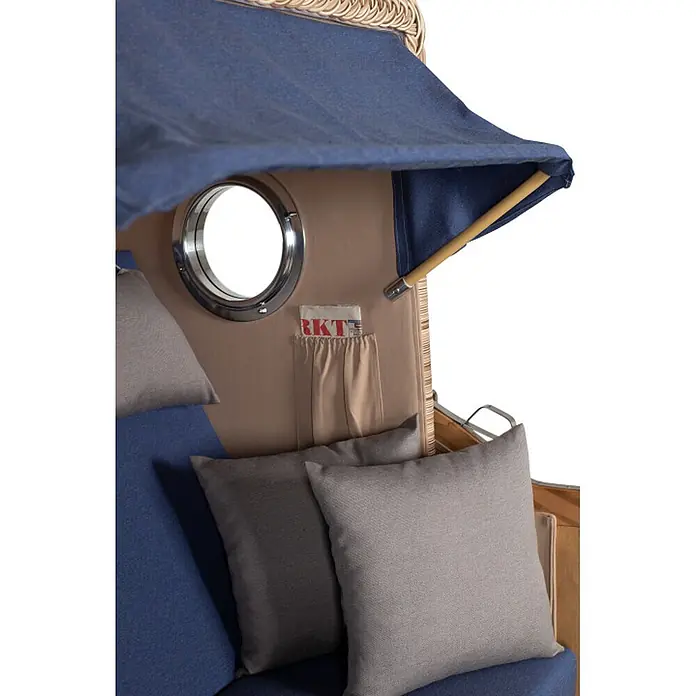 Mr. Deko Strandstuhl Strandkorb Düne - Teakholz. Polyrattan, Rückenlehne verstellbar, PE Shell, B x T x H: 125 x 80 x 170 cm - Strandkorb-Innenansicht mit blauer Markise, Bullauge, beiger Tasche mit Magazin und bequemen grauen Kissen.