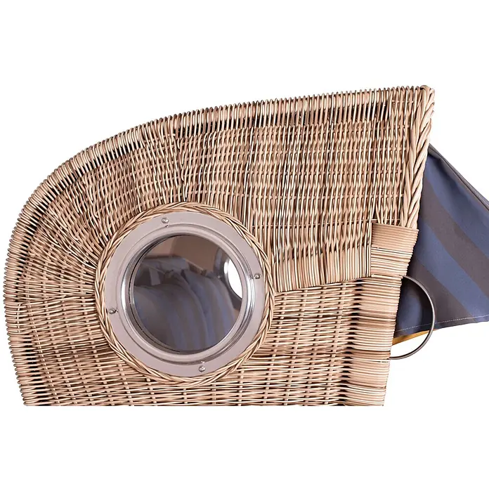 Mr. Deko Strandstuhl Strandkorb Düne Bullauge Teak PE Shell Dessin 582 - Teakholz. Polyrattan, Rückenlehne verstellbar, PE Shell, B x T x H: 125 x 80 x 170 cm - Detailaufnahme eines hellbraunen Strandkorbs aus Korbgeflecht mit rundem Metall-Bullauge und blau gestreiftem Stoff.