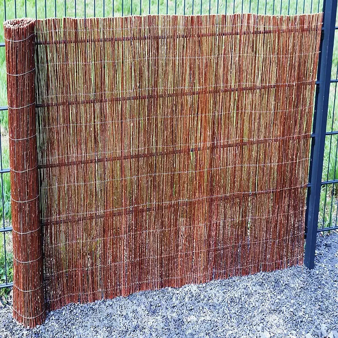 Aquagart Sichtschutzelement 10m x 150 cm Weidenmatte I Sichtschutzmatte - Holz, braun - Braune Weiden-Sichtschutzrolle, teilweise vor einem Metallzaun ausgerollt.