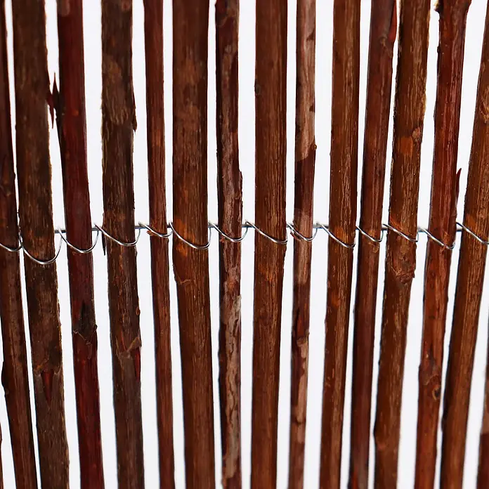 Aquagart Sichtschutzelement 10m x 150 cm Weidenmatte I Sichtschutzmatte - Holz, braun - Dunkelbrauner Zaun aus Holzstäben, mit Metalldraht verbunden.