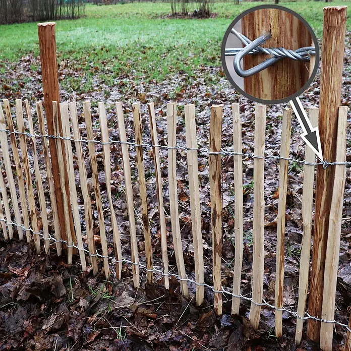 Aquagart Zaun-Set 5m 120cm 4 6cm 5 1,5m Komplett Set - 5 x 1,2 m, braun - Naturholz-Lattenzaun mit Drahtverbindungen im Freien installiert. Nahaufnahme zeigt die verdrehte Drahtbefestigung an einem Pfosten.