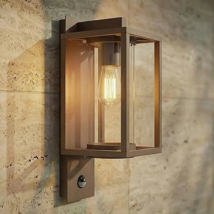 Lucande Außenwandleuchte Ferda - braun / rost, braun / rost, IP44 - Bronzefarbene Außenwandleuchte mit Klarglas, sichtbarer Glühbirne und integriertem Bewegungssensor.