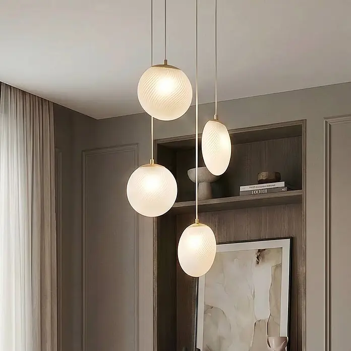 Lucande Pendelleuchte Lunelle - L x B x H: 40 x 40 x 19,5 cm, weiß / opal, weiß, messing, G9 - Cluster moderner Pendelleuchten mit mattierten, gerippten Glasschirmen (kugel- und ovalförmig) und goldfarbenen Beschlägen, von der Decke hängend.