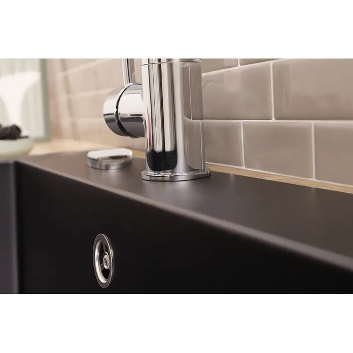 Respekta Einbauspüle Oakville - 60 x 53 cm, Verbundwerkstoff, Schwarz - Schwarze Küchenspüle mit elegantem Chromwasserhahn vor beigen Metrofliesen und Holzplatte.