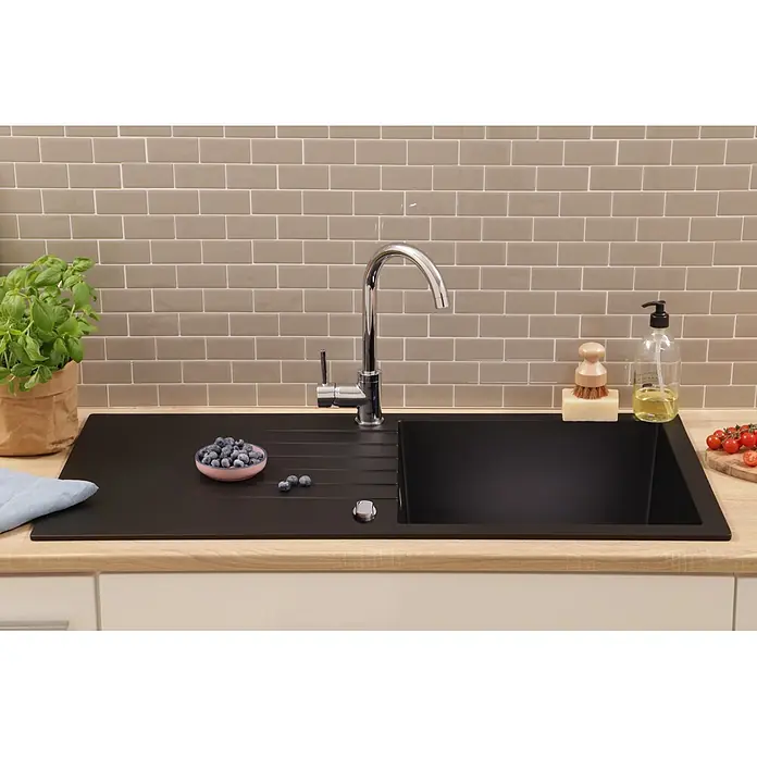 Respekta Einbauspüle Almonto - 100 x 50 cm, Verbundwerkstoff, Schwarz - Moderne schwarze Küchenspüle und Chromarmatur vor einem beigefarbenen Metrofliesen-Spritzschutz, in einer hellen Holzarbeitsplatte.