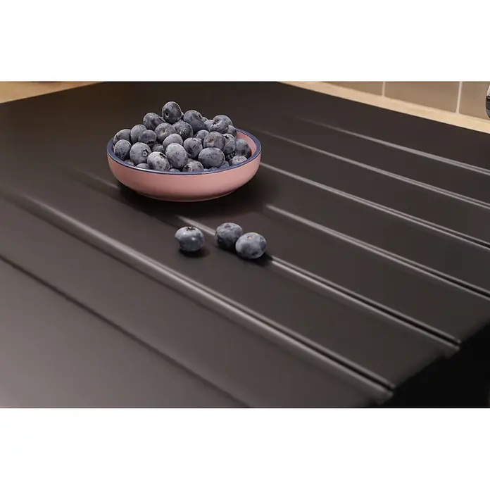 Respekta Einbauspüle Almonto - 100 x 50 cm, Verbundwerkstoff, Schwarz - Dunkle Küchenabtropffläche mit Rillenstruktur, gezeigt mit einer Schale frischer Heidelbeeren.