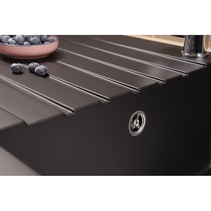 Respekta Einbauspüle Almonto - 100 x 50 cm, Verbundwerkstoff, Schwarz - Dunkelgraue Verbundküchenspüle mit gerippter Abtropffläche. Eine Schale Heidelbeeren und ein Wasserhahn sind in der Nähe.