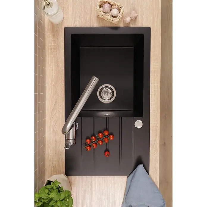 Respekta Einbauspüle Almonto - 76 x 43,5 cm, Verbundwerkstoff, Schwarz - Schwarze Küchenspüle mit integriertem Abtropfbrett und Chromarmatur auf einer Holztheke, von oben gesehen.